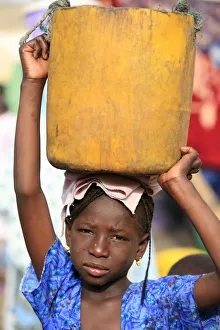 Senegal Prints: Girl carrying a heavy load, St. Louis, Senegal, West Africa, Africa