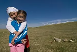 Two girls in a open field near Song Kul, Kyrgyzstan, Central Asia, Asia