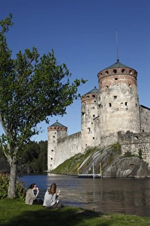 Images Dated 21st June 2009: Girls relaxing beside Olavinlinna Medieval Castle (St. Olafs Castle)
