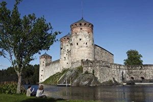 Images Dated 21st June 2009: Girls relaxing beside Olavinlinna Medieval Castle (St. Olafs Castle)