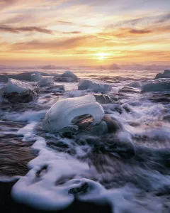 Glacial Prints: Glacier ice on Diamond Beach at sunrise with crashing waves