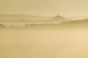Glastonbury Prints: Glastonbury Tor and surrounding hills rising above early morning mist, Glastonbury