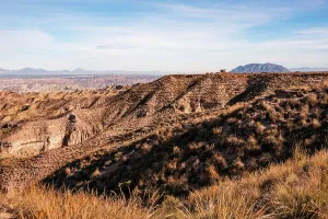 Bright Prints: Golden afternoon light shines on dry hills and eroded formations in the Desierto de Gorafe in Granada
