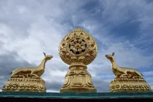 Meditation Prints: Golden Dharma wheel with deer on top of Songzanlin Monastery against a dramatic sky in Yunnan China