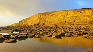 Outlook Prints: Golden evening light on the cliffs in winter at Dunraven Bay