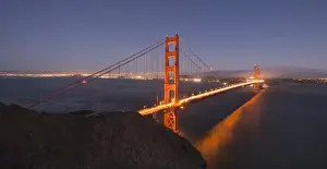 Golden Gate Bridge glowing at sunset with the San Francisco skyline behind