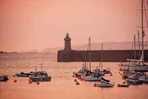 Ports Prints: Golden hour at Saint Peter Port with yachts and lighthouse against a colorful sky over the Channel Islands