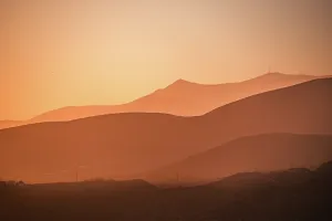 Silhouettes Prints: Golden hues blanket the rolling mountains of AlmerAa