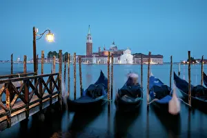 Wanderlust Prints: Goldolas drift on lagoon during twilight with historic structures in background in Venice Italy