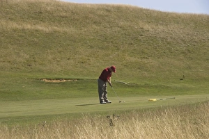 One Young Man Only Prints: Golfer putting on public golf course, Cleeve Hill, The Cotswolds, Gloucestershire