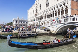 Typically Venetian Prints: Gondola, with tourists, under the Ponte de Paglia