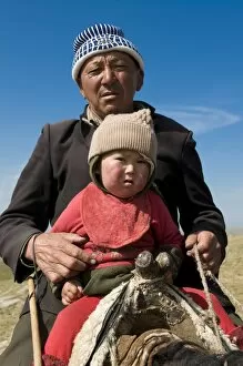 Grandfather with his grandson riding a horse, Song Kul, Kyrgyzstan, Central Asia, Asia