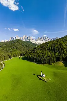 South Tyrol Prints: Green forest and meadows surrounding the small Ranui church and Odle in spring