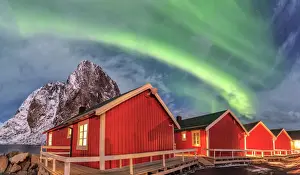 Green Colour Prints: The green light of the Northern Lights (aurora borealis) lights up fishermans cabins