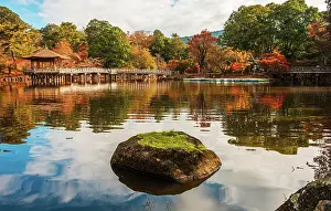Stillness Prints: Green moss covered rock centered in a calm reflecting pond with autumnal surroundings