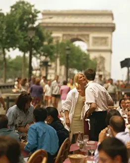 Kissing Prints: Greeting friends at an outdoor cafe on the Champs Elysees with the Arc de Triomphe behind