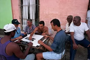 Cuba Gallery: A group of men sitting around a table playing dominoes outdoors, Trinidad