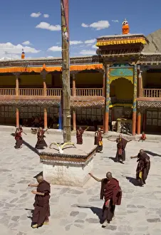 Group of monks dancing in the monastery courtyard rehearsing