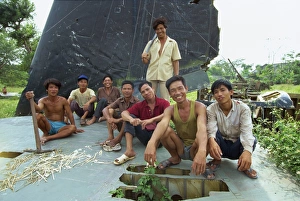 Ha Noi Prints: A group of smiling park workers on the tail plane of