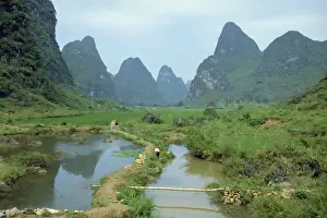 Guilin Prints: In Guilin, irrigation channel among rice paddies in area of limestone towers