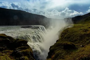 Sights Prints: Gullfoss waterfall shows golden cliffs and blue water during late afternoon light in Iceland's landscape