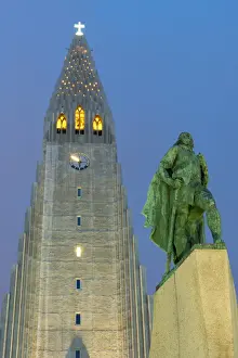 Clock Tower Prints: The Hallgrims Church with a statue of Leif Erikson in the foreground lit up at night