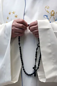 Close Up View Prints: Hand-carved Roman Catholic rosary beads, priest praying The Mystery of the Holy Rosary