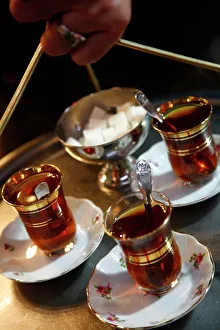 Glass Prints: Hand holding a tray with Turkish tea, Istanbul, Turkey, Europe