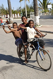 Portraits Prints: Happy boys cycling through the streets of Toliara, Madagascar, Africa