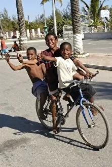 Images Dated 21st August 2007: Happy boys cycling through the streets of Toliara, Madagascar, Africa
