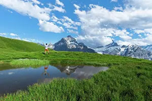 Grindelwald Prints: Happy hiker reflecting in the water of a small lake below the Bernese Oberland mountains