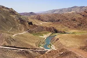 Ghor Prints: Hari Rud river flowing through fertile valley at base of red rock mountains