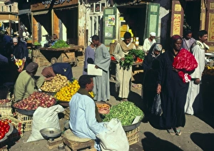 Small Business Prints: Hawker at vegetable and fruit stall with people passing by, local market