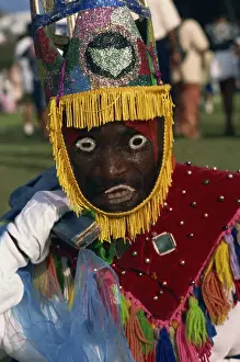 Masked Prints: Head and shoulders portrait of a person wearing mask headdress and brightly coloured costume