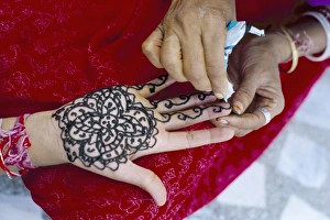 Ability Prints: Henna designs being applied to a womans hand