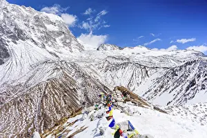 Snowcapped Prints: High-altitude view north from Kyanjin Ri summit with prayer flags and dramatic snow-covered ridges above Ubra