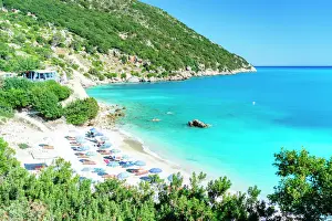 Sun Lounger Prints: High angle view of beach umbrellas on the idyllic Vouti beach framed by lush plants