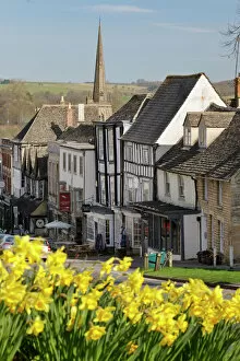 Typically English Gallery: High Street and Burford Church with daffodils, Burford, Cotswolds, Oxfordshire, England