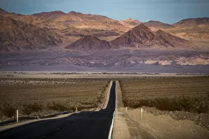 Traditionally American Gallery: Highway through Death Valley with mountains in the distance, California, United States of America