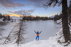 Sondrio Prints: Hiker admires Lago Azzurro completely frozen at dawn, Spluga Valley, Province of Sondrio