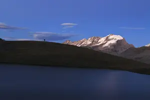 Alpi Graie Prints: Hiker admires sunset on Rossett Lake at an altitude of 2709 meters