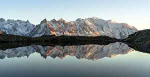 Recreational Pursuits Prints: Hiker admiring Dent du Geant and Mont Blanc covered with snow reflected in Lacs des