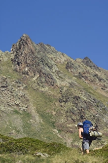 Back Pack Prints: Hiker on climbing trail in hiking area of Pic de Coma Pedrosa, Andorras highest mountain