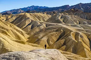Sandstone Gallery: Hiker in the colourful sandstone formations, Zabriskie Point, Death Valley, California