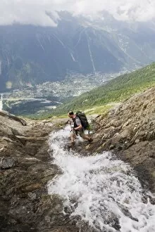 Images Dated 15th July 2009: Hiker crossing a stream above Chamonix Valley, Rhone Alps, France, Europe