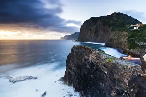 Search Results: Hiker with head torch admiring the blue hour from cliffs at Miradouro Do Guindaste