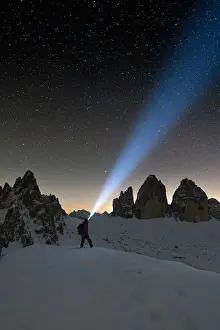 Mid Adult Man Prints: Hiker with head torch admiring stars on Monte Paterno and Tre Cime di Lavaredo