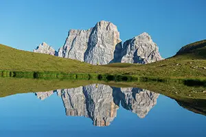 Mid Adults Prints: Hiker and Mount Pelmo reflected in the water of Baste Lake on a sunny day