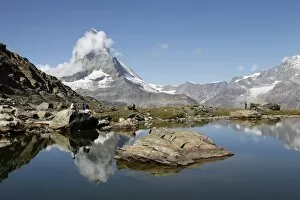 Images Dated 27th August 2009: Hiker resting at Riffelsee and the Matterhorn behind, Zermatt, Valais, Swiss Alps
