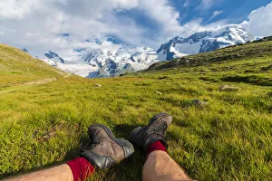 Typically Swiss Prints: Hiker rests on grass looking towards Monte Rosa massif